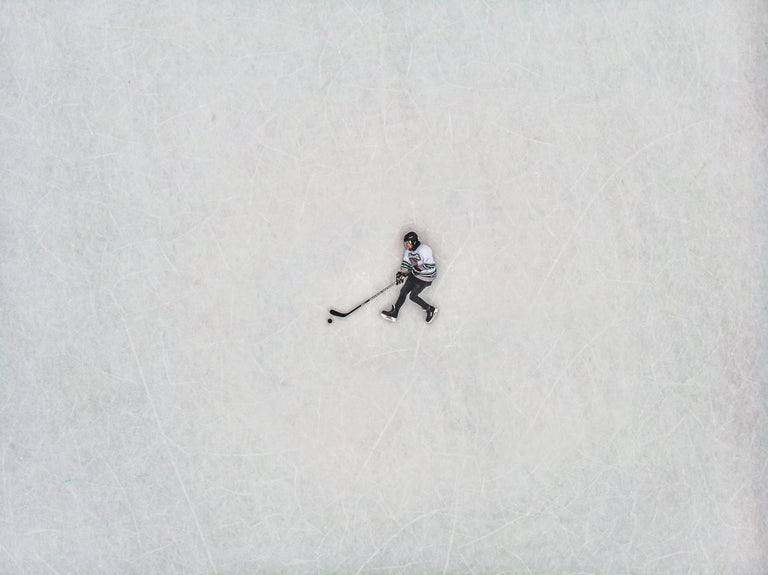 Birds-eye view of a hockey player laying on the ice.