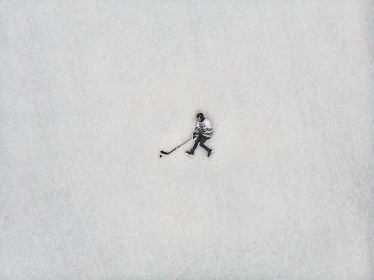 Birds-eye view of a hockey player laying on the ice.